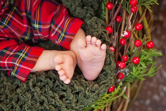 detail of Scottish baby boy feet and legs wearing tartan trousers
