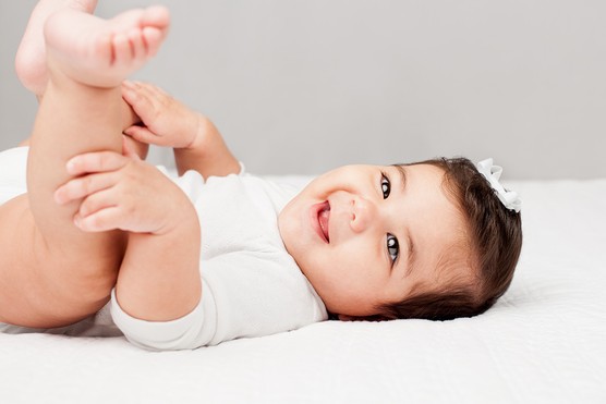 Baby lying down smiling at the camera