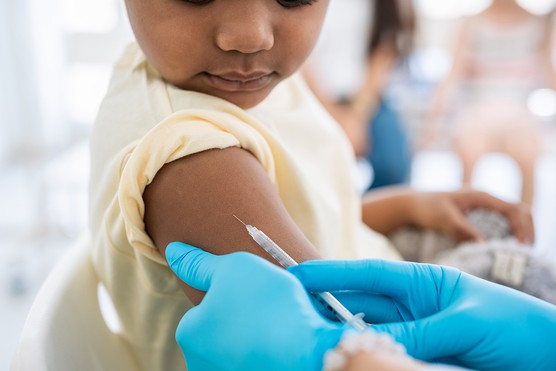 close up of child having an injection in his arm