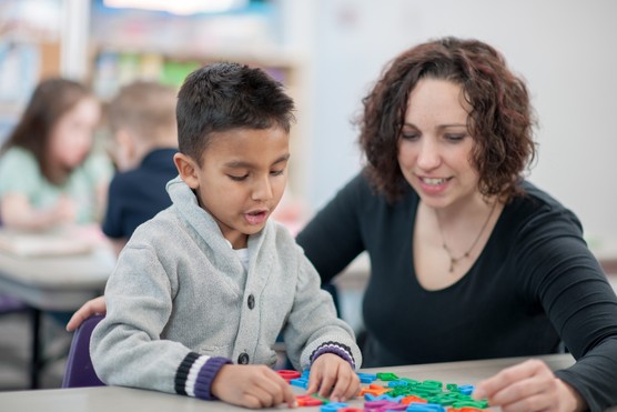 boy with teacher as he completes his baseline reception test