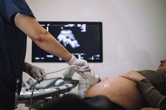 Gynecologist doing an ultrasound of pregnant woman in hospital