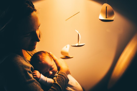 Mother cradling baby at the night.