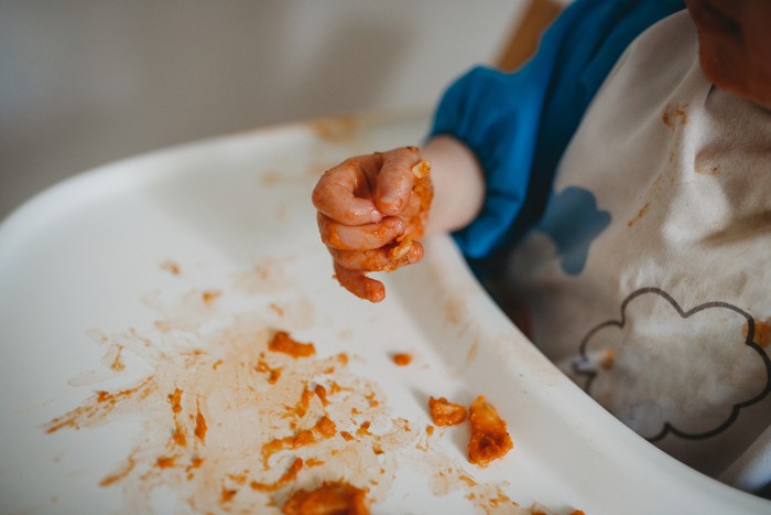 Close up of a baby's hands while eating and making a mess