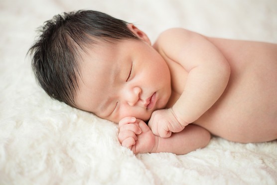 Korean baby boy asleep lying on rug