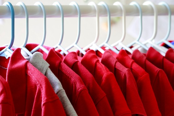red school t shirts hanging on a rack