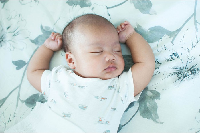 unique-baby-boy-names baby boy lying on a sheet decorated with leaves