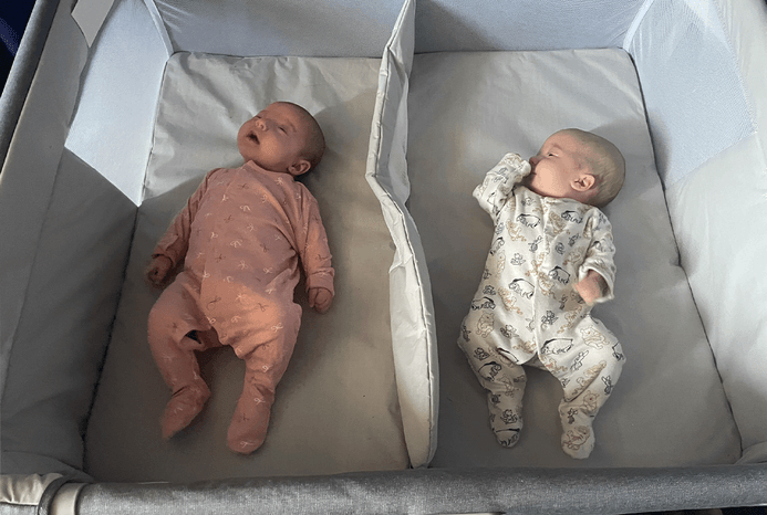 2 babies asleep in Chicco Next2Me Twin crib