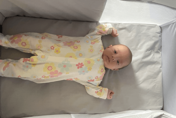 One baby lying in Chicco Next2Me Twin crib