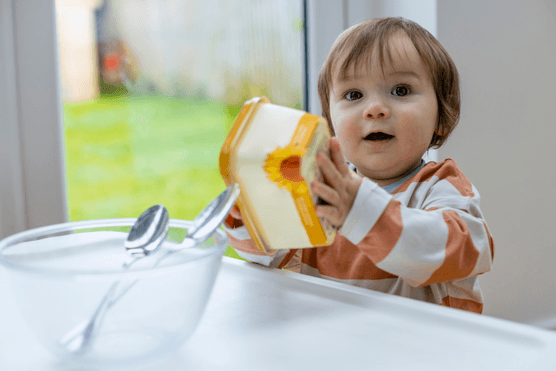 toddler holding butter tub